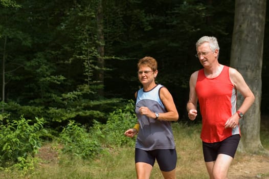 senior couple running in the woods
