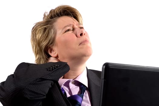 A business woman grabbing her neck in pain. She's worked to long and hard on the laptop.