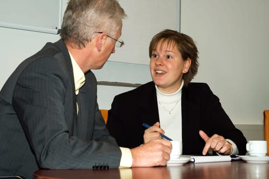 Two people discussing. Focus is on the woman.