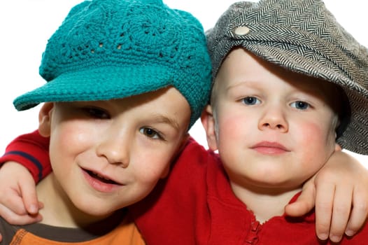 Two lovely brothers wit hats, holding each other.