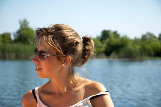 Beautiful woman with glasses in front of a lake.