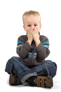 Boy holding his hands against his mouth.