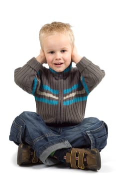 Boy holding his hands against his ears.