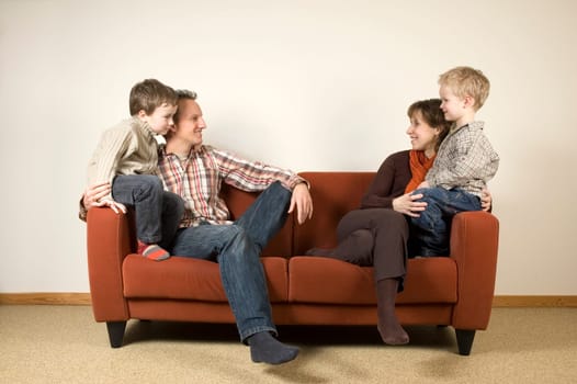 Nice family picture, sitting together on a couch.