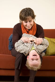 Mother playing with her son on the couch. Nice family picture.