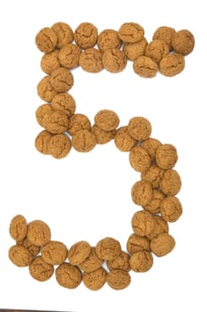 Little ginger nuts in the form of the digit five. These little ginger nuts are used in Holland for the "Sinterklaas"" party, which is at Dec 5 every year. Sinterklaas is a sort of Santa Claus. In Holland these ginger nuts are called ""pepernoot"". Isolated on white."