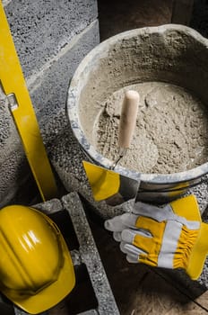 Tools for bricklayer bucket with a solution and a trowel, close-up