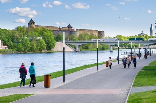 NARVA, ESTONIA - MAY 22 2015: Narva River embankment with vacationers people and the border of Russia and the European Union