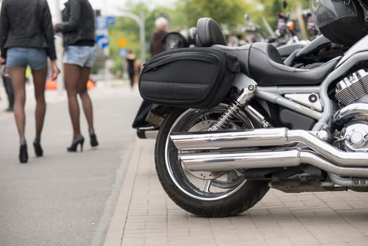 close up of the motorcycle exhaust with sexy legs on background