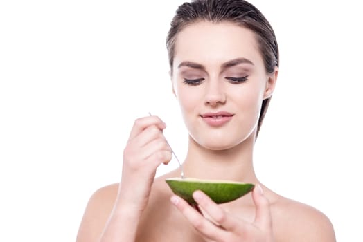 Beautiful bare shoulder woman eating fresh green fruit