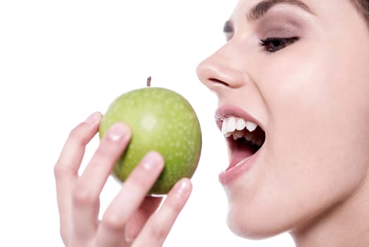Woman eating a green apple over white background