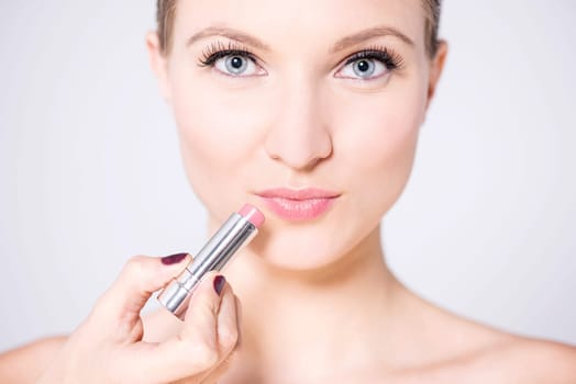 Stunning female model using glossy lipstick