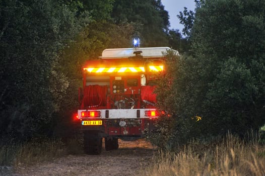 Fire trucks in a forest road the night after a forest fire in the French department of Gard.