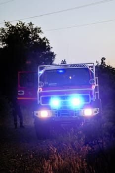 Fire trucks in a forest road the night after a forest fire in the French department of Gard.