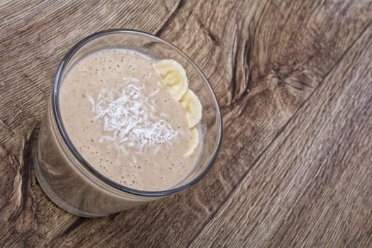 Chocolate drink with coconut and banana on a wooden backhģround