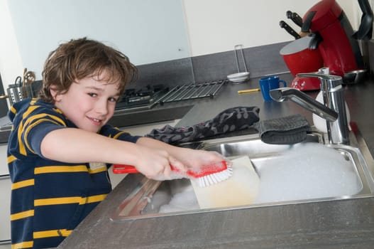 Boy doing the dishes in a modern kitchen