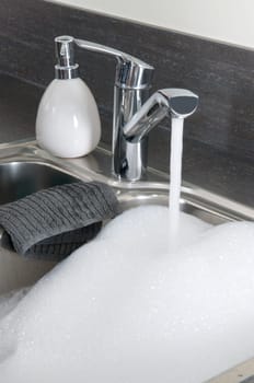 Closeup of a sink in a modern kitchen, ready to do the dishes.