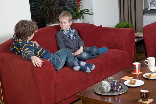 Two brothers are sitting on a couch in the livingroom