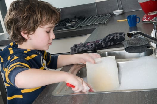 Boy doing the dishes in a modern kitchen
