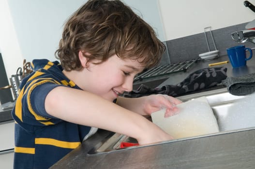 Boy doing the dishes in a modern kitchen