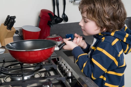 Young boy learning to cook in a modern kitchen