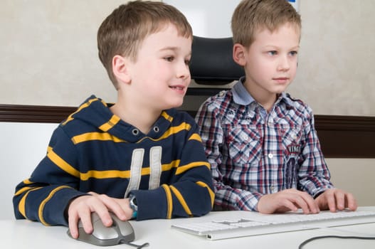 Two friends are having fun while working on a computer.