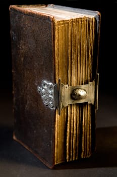 Nice old bible with an old lock on a black background.