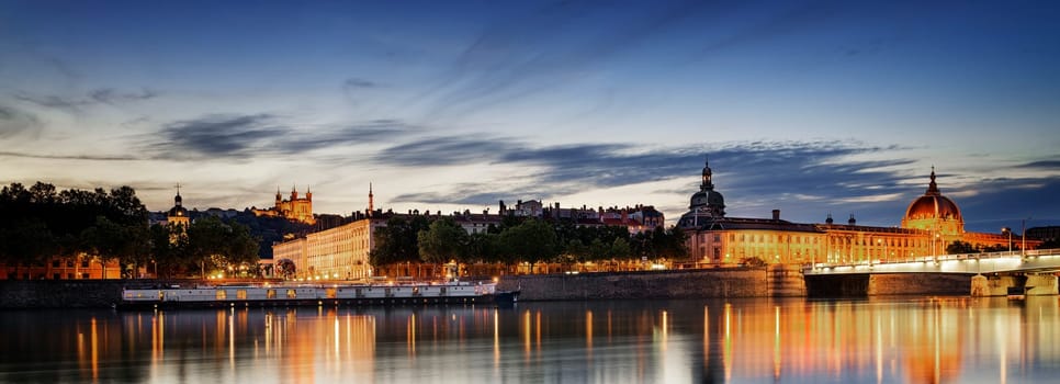 night view from Rhone river in Lyon city with Hotel Dieu and Fourviere cathedral, France