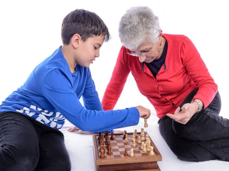 Grandmother with her grandson playing chess. white background.