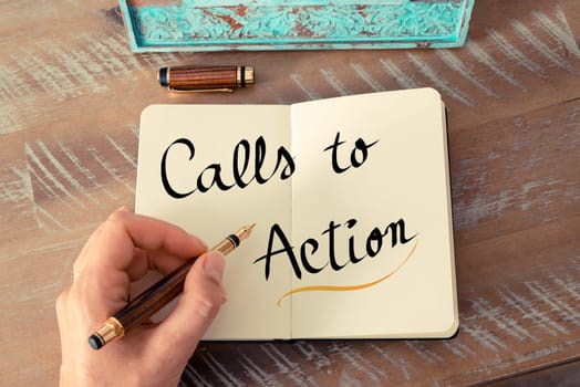 Retro effect and toned image of a woman hand writing a note with a fountain pen on a notebook. Handwritten text Calls To Action as business concept image