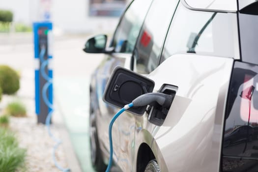 Power supply for electric car charging.  Electric car charging station. Close up of the power supply plugged into an electric car being charged.