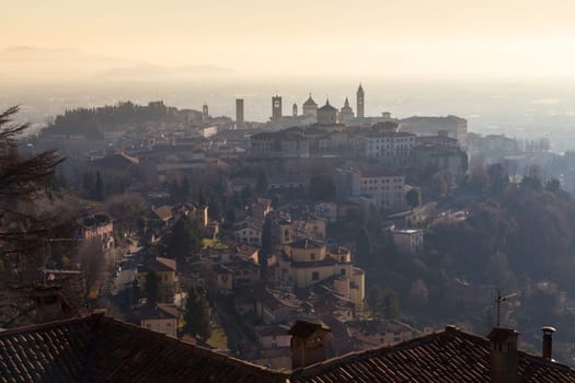 View over Old Town buildings in the ancient city of Bergamo, Lombardia, Italy on a misty winter day, taken from San Virgilio point.