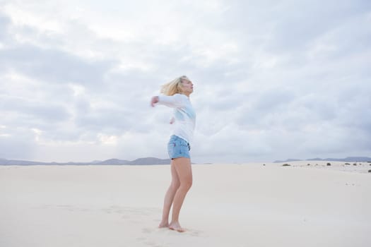 Relaxed woman enjoying freedom feeling happy at beach in the morning. Serene relaxing woman in pure happiness and elated enjoyment with arms outstretched.