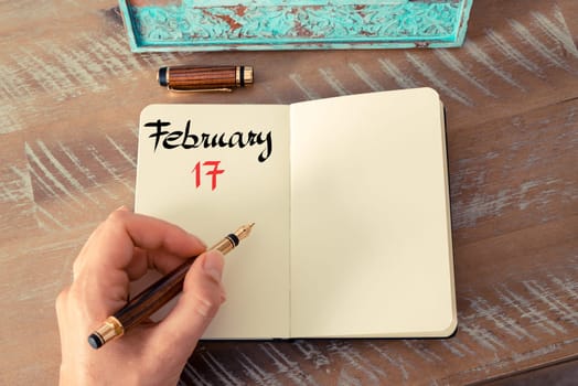 Concept image of February 17 Calendar Day with empty space for text as handwritten note with fountain pen on a notebook