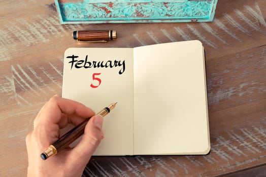 Concept image of February 5 Calendar Day with empty space for text as handwritten note with fountain pen on a notebook