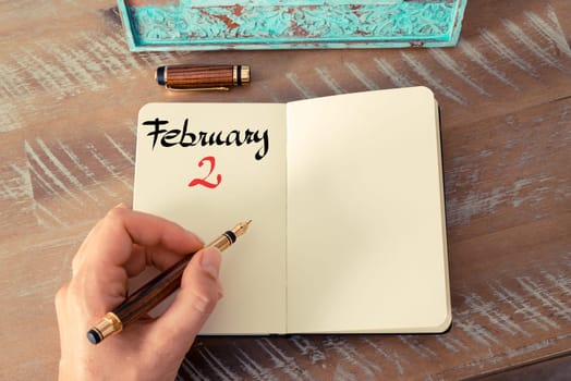 Concept image of February 2 Calendar Day with empty space for text as handwritten note with fountain pen on a notebook