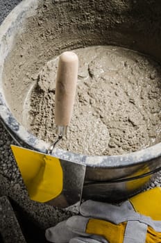 Tools for bricklayer bucket with a solution and a trowel, close-up