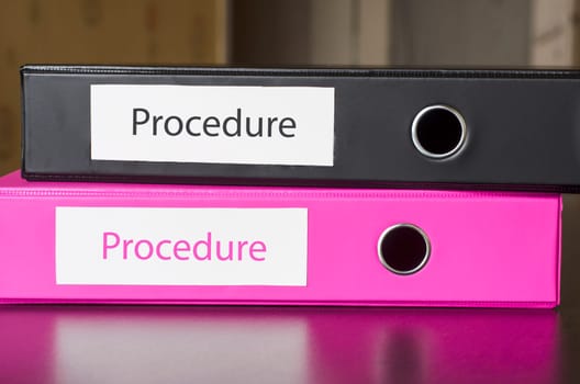 Bright office folders over dark background and procedure text concept