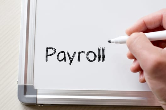 Human hand writing payroll on whiteboard