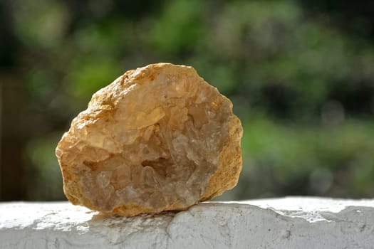 Mineraien Stein Celestite - Druse on white wall against a green natural background