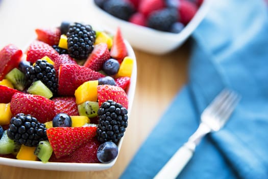 Healthy fresh fruit salad with strawberries, blackberries, mango, blueberries and kiwi.