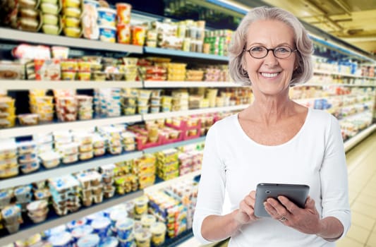 Woman in departmental store choosing items from tablet pc