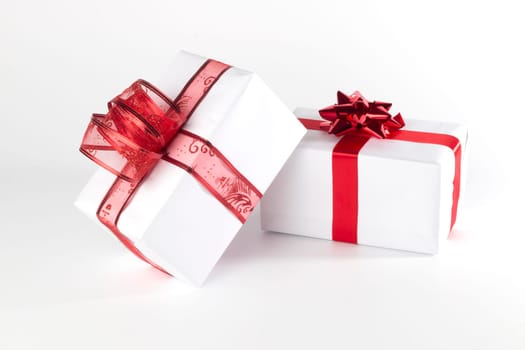 White presents with red ribbons and bows, isolated on white background
