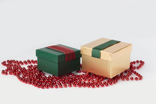 Two presents, green and gold, with ribbons, isolated on white background