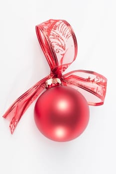 Red christmas ball with ribbon bow, isolated on white background