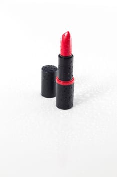 red lipstick with water drops isolated on white background