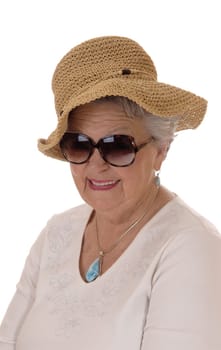 A lovely senior woman in her seventies wearing a straw hat and .sunglasses, smiling, isolated for white background..