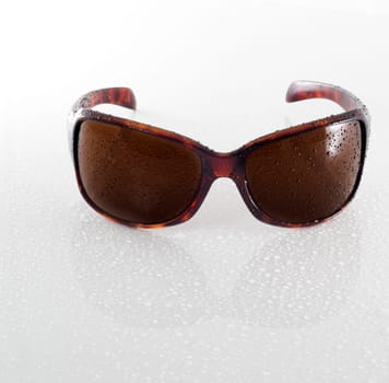 Wet sunglasses isolated on white background