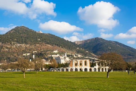Panoramic view of a Roman amphitheater located next to an Umbrian medieval town