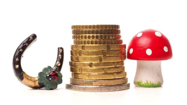 Stacked coins with a clover and a fly agaric